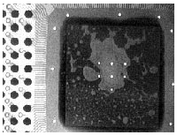 Die attach, showing voids in the epoxy connecting the silicon to the metal lead frame.